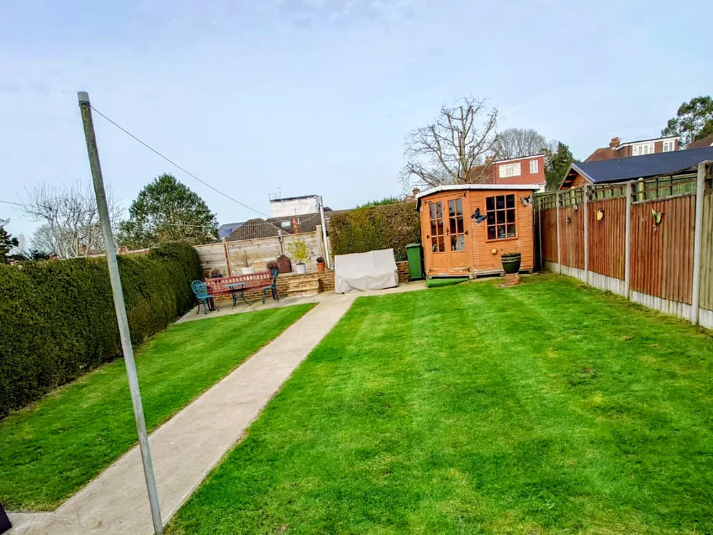 Small back garden with freshly mowed lawn and summer house